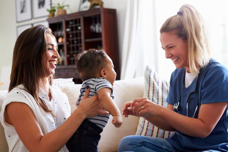Female healthcare worker visiting a young mom and her infant son at home.