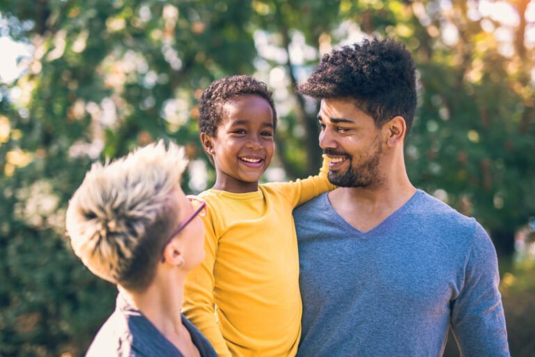 Happy young mixed race couple spending time with their daughter having fun