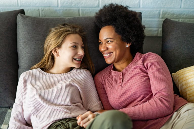 Loving foster care parent mother embraces teen daughter.